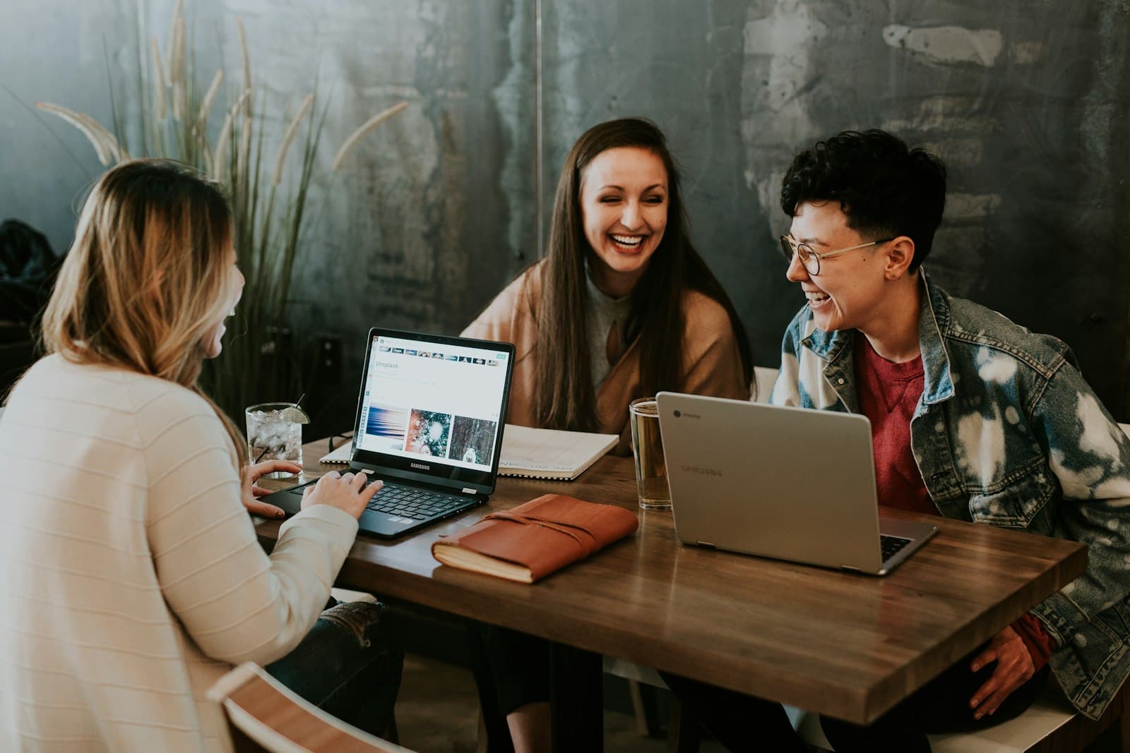 Alunos estudando juntos em uma mesa com notebooks